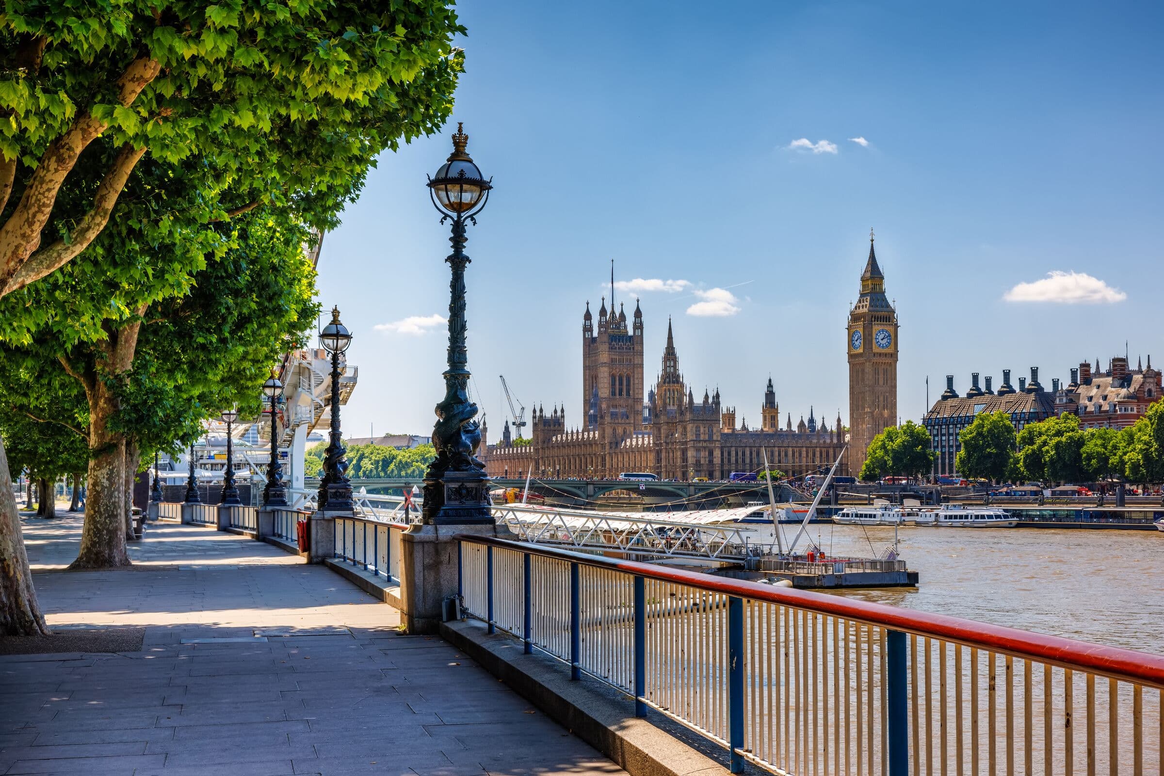 Riverside walk along the Thames with Parliament in the distance