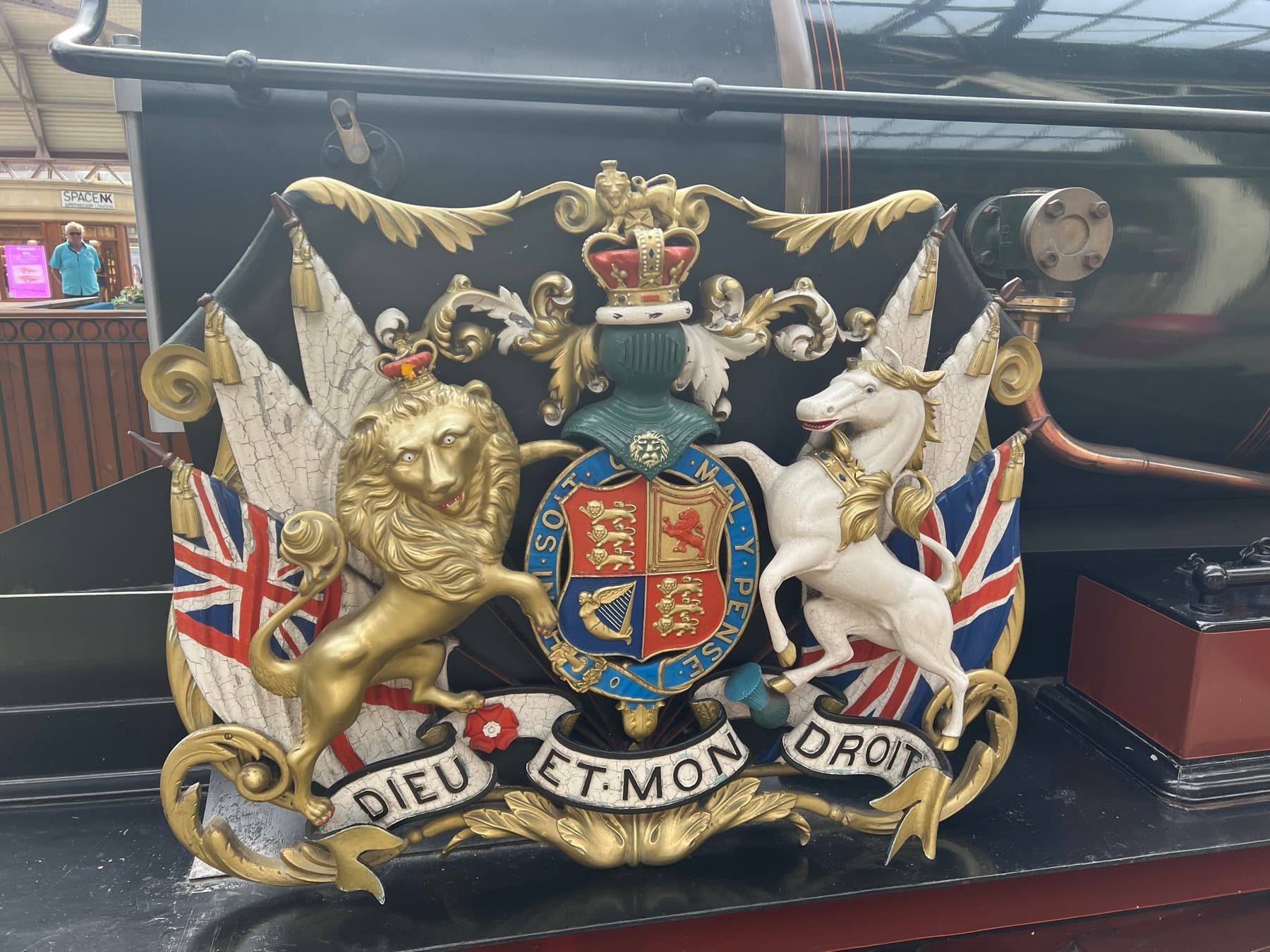 The British royal coat of arms, with the lion, the unicorn and the motto 'Dieu et mon droit'
